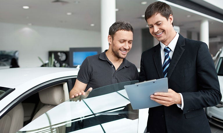 Driver and salesman looking at clipboard