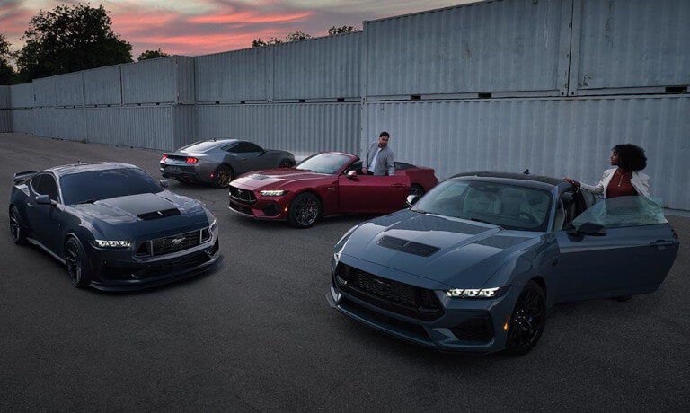 2025 Ford Mustang lineup parked by shipping containers