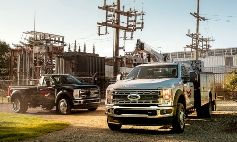 2025 Ford Super Duty pair parked by a power plant