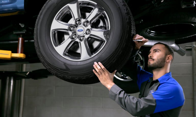 Ford technician inspecting tire